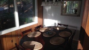 Un comedor con una mesa redonda, seis sillas y posavasos de fibras naturales.