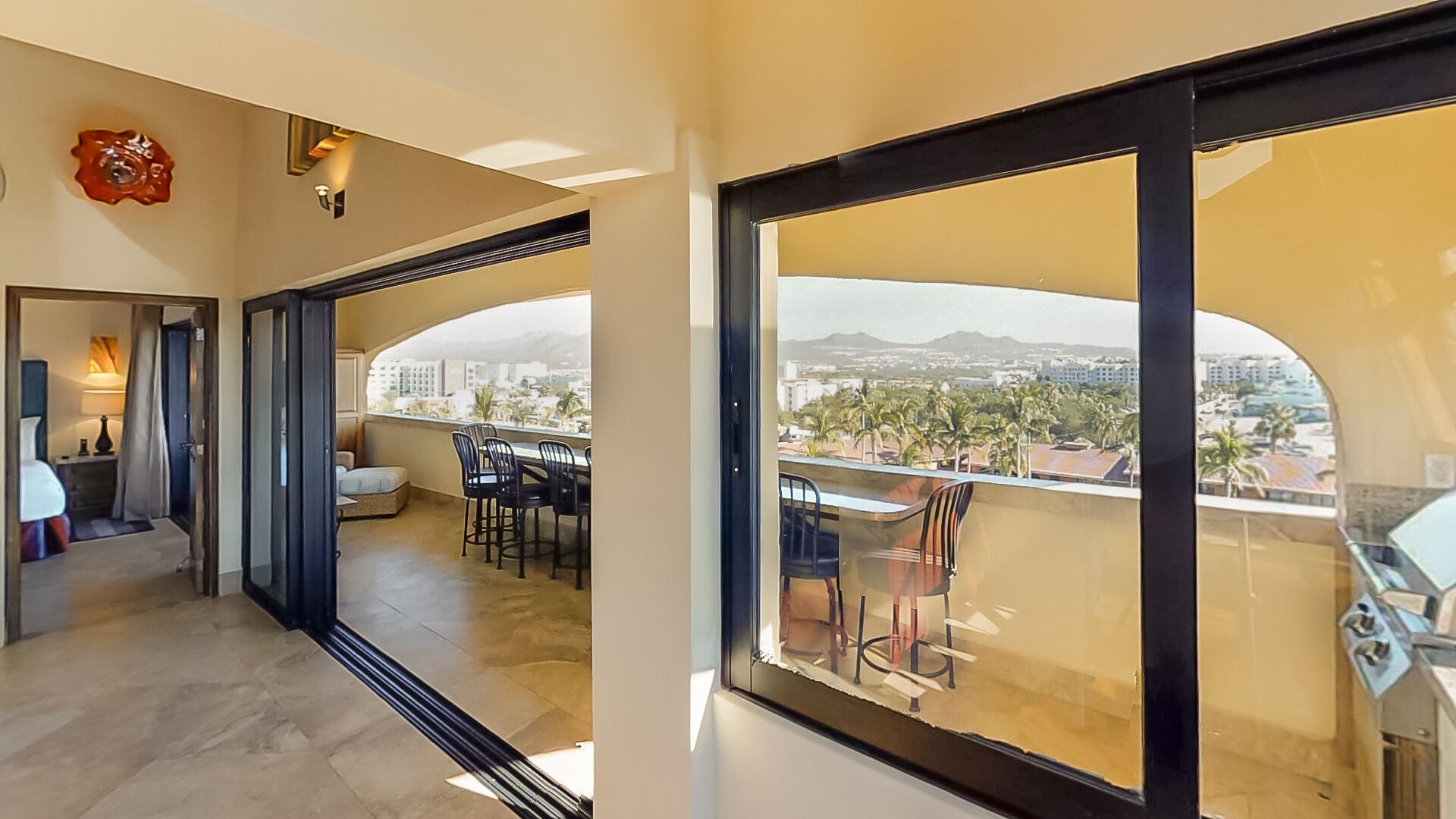 Ein modernes Hotelzimmer mit Balkon, Essbereich und Blick auf die Stadt.