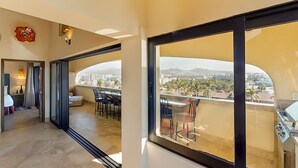 Ein modernes Hotelzimmer mit Balkon, Essbereich und Blick auf die Stadt.