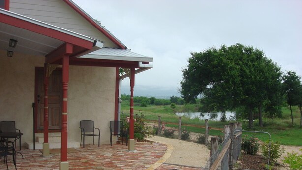 Un patio abrité, doté de chaises et offrant une vue sur un lac.