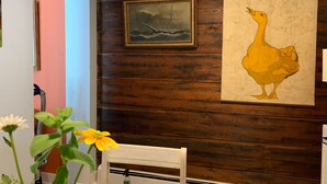 A room with wooden paneling, a framed painting of a ship, and a large illustration of a bird. - Discover Coastal charm, just a quick 26-min drive away (Damariscotta)