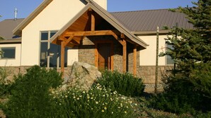 A house with a stone foundation, a wooden porch, and a metal roof. - POSTCARD VIEWS-3 min TO TOWN, 5 TO SLOPES 10 ACRES 2100 SQFT  (Crested Butte)