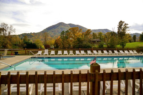 Relax by the pool surrounded by the serene beauty of autumnal trees and a mountain view.