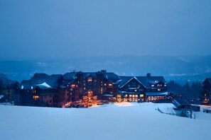 Stunning lodge with a central building and multiple windows, offering a warm and inviting atmosphere.