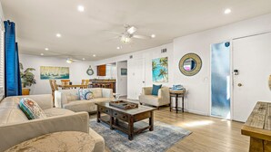 Ein geräumiges Wohnzimmer mit einer Couch, einem Couchtisch und einem Essbereich mit Stühlen und einem Tisch.