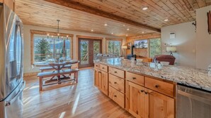 A spacious kitchen with wooden cabinets, granite countertops, and a large island.