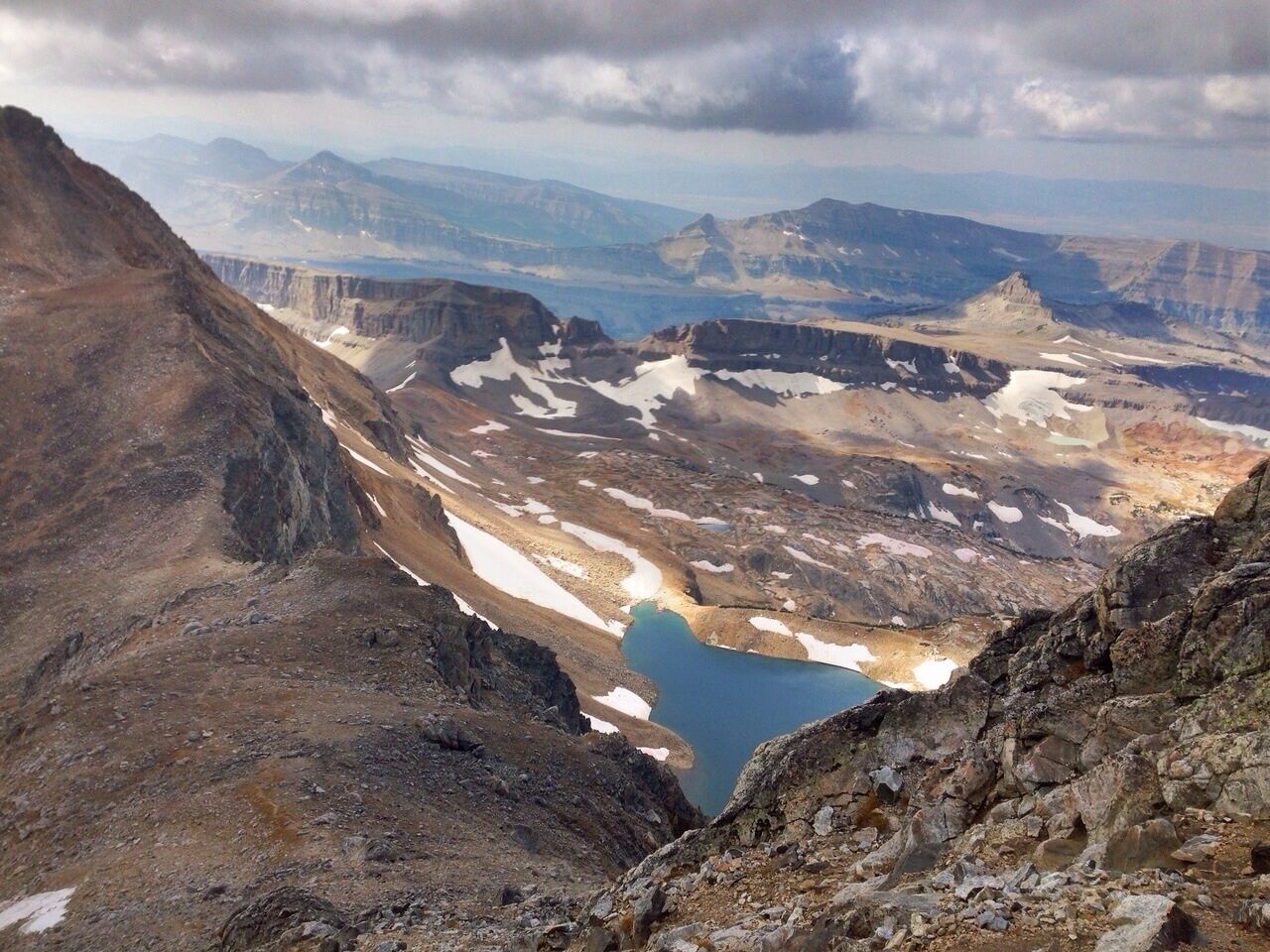 A mountainous landscape with a glacial lake and rugged terrain.