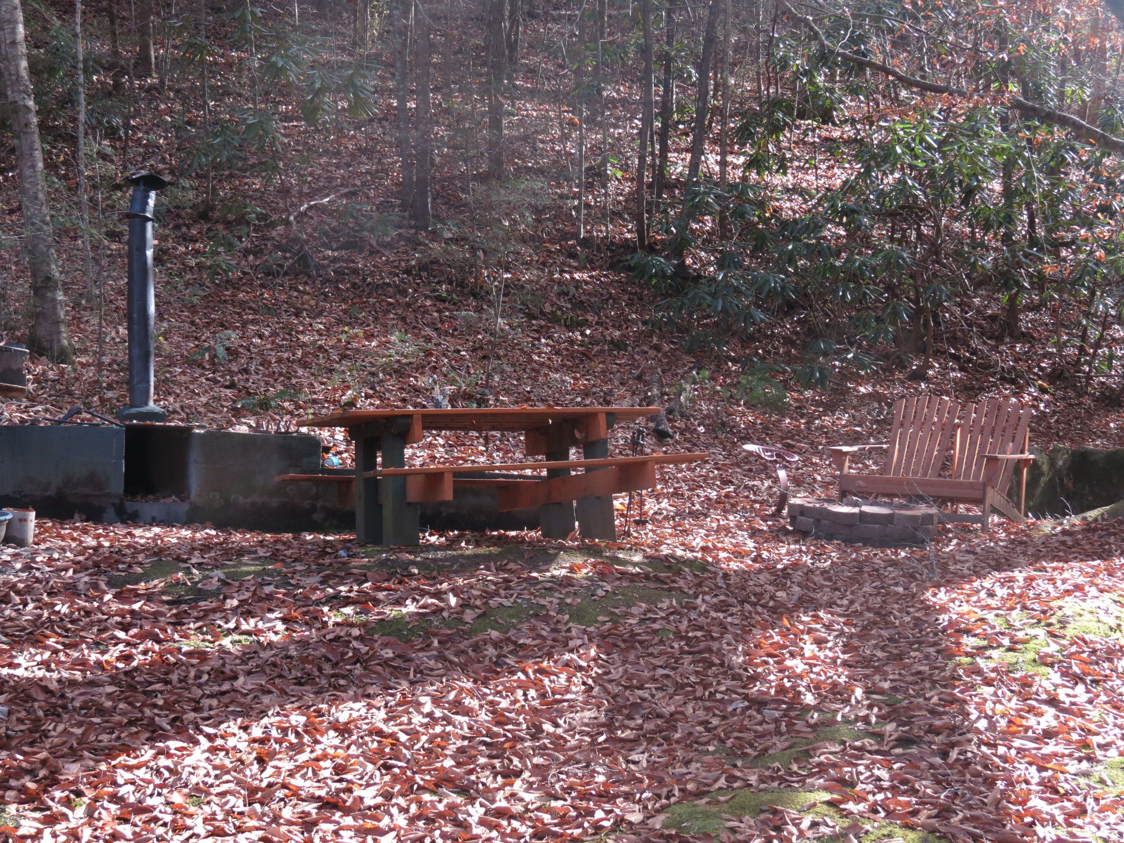 Un parque con un banco de madera, una mesa de picnic y una estructura metálica.