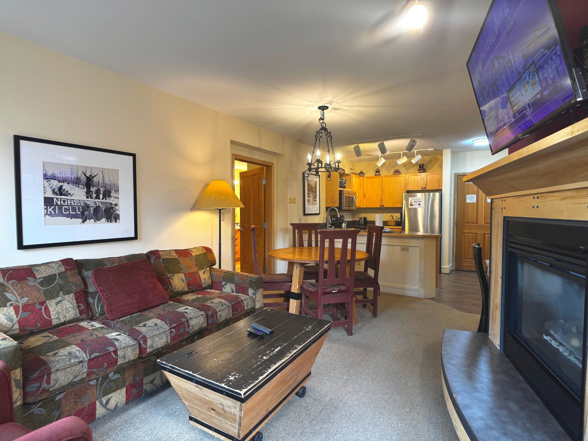 A living room with a sofa, a coffee table, a fireplace, and a television.