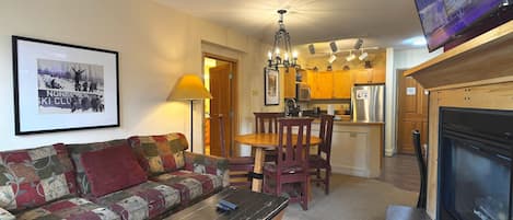 Una sala de estar con sofá, mesa de centro, chimenea y televisión.