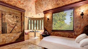 Une chambre à coucher avec un lit, une coiffeuse avec un miroir et une fenêtre avec des stores.