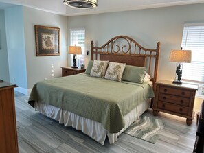 A bedroom with a bed, nightstands, a dresser, a mirror, and a window with blinds. - Crown Pointe Home with Lake Views! (Naples)