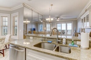 Kitchen features a large island with a stainless steel sink and double sink, oven, and microwave.