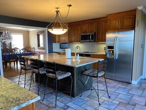 A modern kitchen with a central island, stainless steel appliances, and patterned bar stools. - The best VIEWS and place to make MEMORIES on Lake Norman!!! Mooresville, NC (Mooresville)