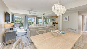 Un salon moderne avec une table à manger, un canapé et un lustre.