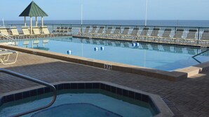 A swimming pool with lounge chairs and a hot tub, with a view of the ocean. - Sunglow, Beachfront Deluxe - 2 bed, 2 bath - ocean front unit (Daytona Beach Shores)