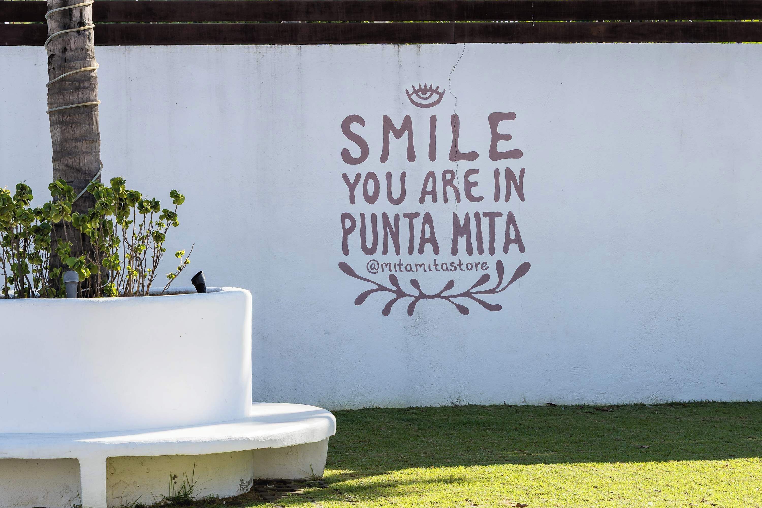 Una pared con un mensaje motivacional y un nombre de usuario de redes sociales.