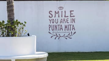 Una pared con un mensaje motivacional y un nombre de usuario de redes sociales.