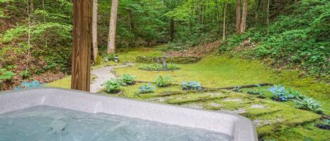 A hot tub with a view of a forested area.