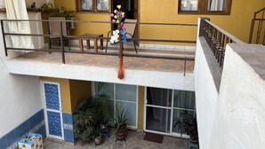 A multi-level building with a balcony, potted plants, and a staircase. - Pacefull Condo in Puerto Vallarta  (Lomas del Coapinole)