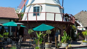 A windmill with a red and white structure, surrounded by outdoor seating and potted plants. - 3 bedroom 2.5 bath 2,200 SF within Solvang Danish Village (Solvang)