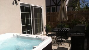 A hot tub in a backyard with a patio table and chairs, a grill, and a wooden fence. - 3 bedroom 2.5 bath 2,200 SF within Solvang Danish Village (Solvang)