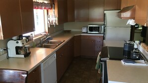 A compact kitchen with a dishwasher, a coffee maker, a microwave, and a refrigerator. - Lake View Home Walking Distance to Town and Vin du Lac Winery (Chelan)