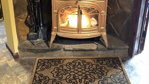 A stone wall with a wood-burning stove. - Little Manistee River Cabin (Irons)