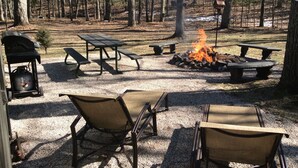 A campsite with picnic tables, fire pit, and outdoor seating. - Little Manistee River Cabin (Irons)