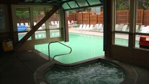 Ein Whirlpoolbereich mit Blick auf einen Pool und Liegestühle im Freien.