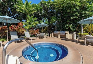A circular pool with a metal ladder, surrounded by lounge chairs and umbrellas, with a grill and seating area in the background. - Luxury Wailea Villa l Stunning Remodel l 
Couples Retreat l Only 5 Star Reviews (Kihei)