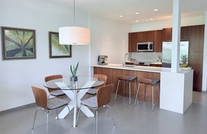 A modern kitchen with a central island, stainless steel appliances, and wooden cabinetry.