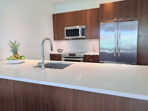 A modern kitchen with a stainless steel refrigerator, a microwave, and a built-in oven.