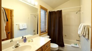 A bathroom with a white sink, mirror, and toilet, a shower with a curtain, and towels on the wall. - PRL3 by Park City Experience - Ultimate convenience near Deer Valley and Main St (Park City)