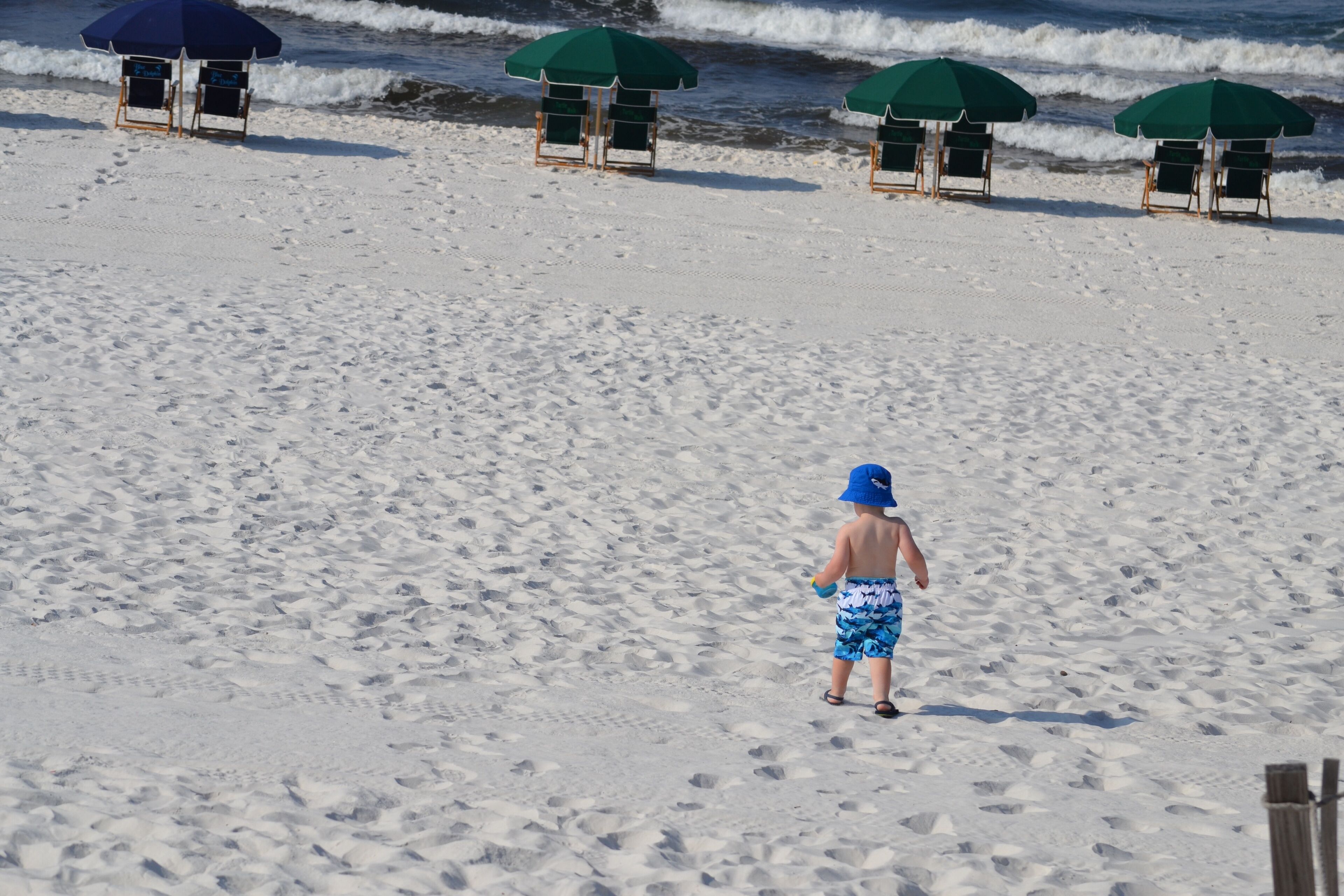 A beach with footprints leading to a lifeguard stand.