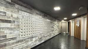Un pasillo con pared estampada, suelo negro y puertas a la derecha.