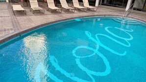 Una piscina con borde de azulejos y un diseño azul en la superficie del agua.