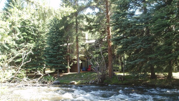 A cabin surrounded by dense forest and a flowing river. - Gore Creek just off the back deck, Free Bus, Wi-Fi, Hot Tub, Summer Pool (Vail)