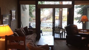 A cozy living room with a sofa, chairs, and a coffee table. There are framed pictures on the wall and a lamp on the side table. - Gore Creek just off the back deck, Free Bus, Wi-Fi, Hot Tub, Summer Pool (Vail)