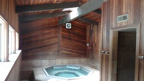 A spa area with a hot tub, wooden beams, and a tiled floor. - Gore Creek just off the back deck, Free Bus, Wi-Fi, Hot Tub, Summer Pool (Vail)