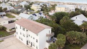 A residential area with multiple two-story houses, a paved driveway, and a view of the beach. - Ocean Song - Hot Tub (St. Augustine)