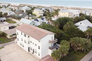 A residential area with multiple two-story houses, a paved driveway, and a view of the beach. - Ocean Song - Hot Tub (St. Augustine)