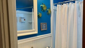 A bathroom with a sink, toilet, and shower curtain. - Marathon Historic Apartments-heart of Downtown - Charming 1 bedroom (Seward)
