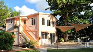 A two-story house with a staircase, outdoor seating, and a large tree. - Waterfront Luxury Living Inside & Out, Gulf View, On the Water!! (Marathon)