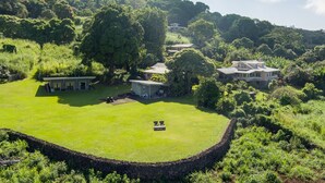 Un'ampia tenuta circondata da rigogliosa vegetazione e dolci colline, con diversi edifici.