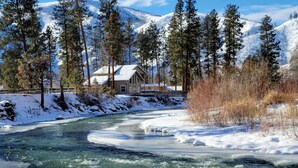 A house by a river with snow-covered mountains in the background. - Riverhouse Retreat on East Fork of the Bitterroot - Stunning Views & Tranquility (Conner)