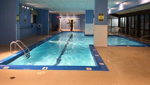 An indoor swimming pool with clear lane markings, a no diving sign, and a lifeguard chair.