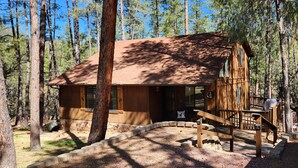 A cabin with a wooden exterior, a porch, and a stone foundation. -  "Palms to Pines Cabin" - Your home away from home... ☆ 5/5 ☆ Star Rated (Pine)