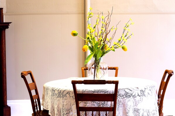 A dining table with a floral centerpiece, surrounded by wooden chairs.