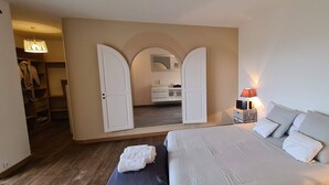Een slaapkamer met een bed, nachtkastje, lamp, kledingkast en spiegel.